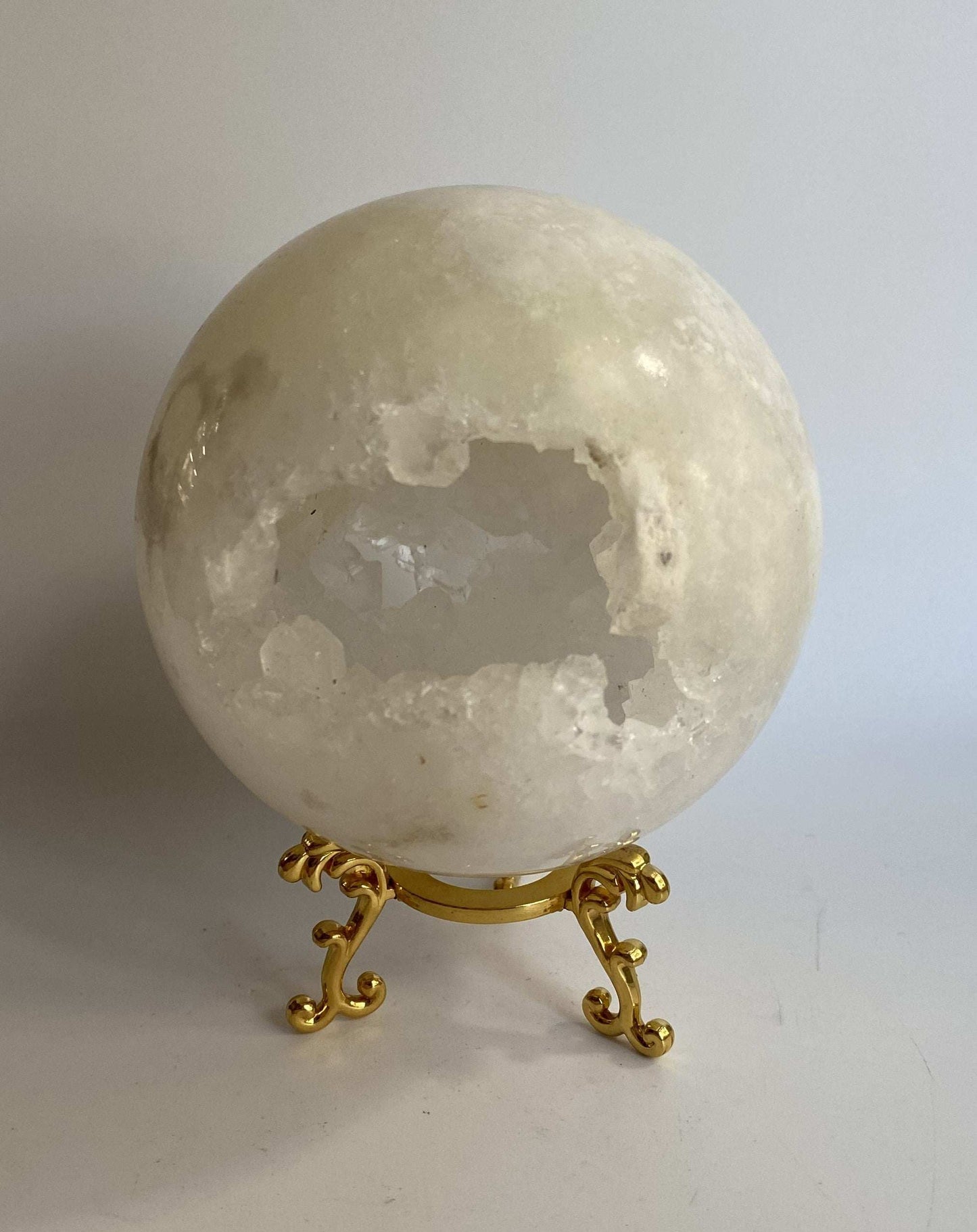 Sfera din Cuart Alb cu suport metalic auriu, piatra semipretioasa sculptata circular, decorativa.