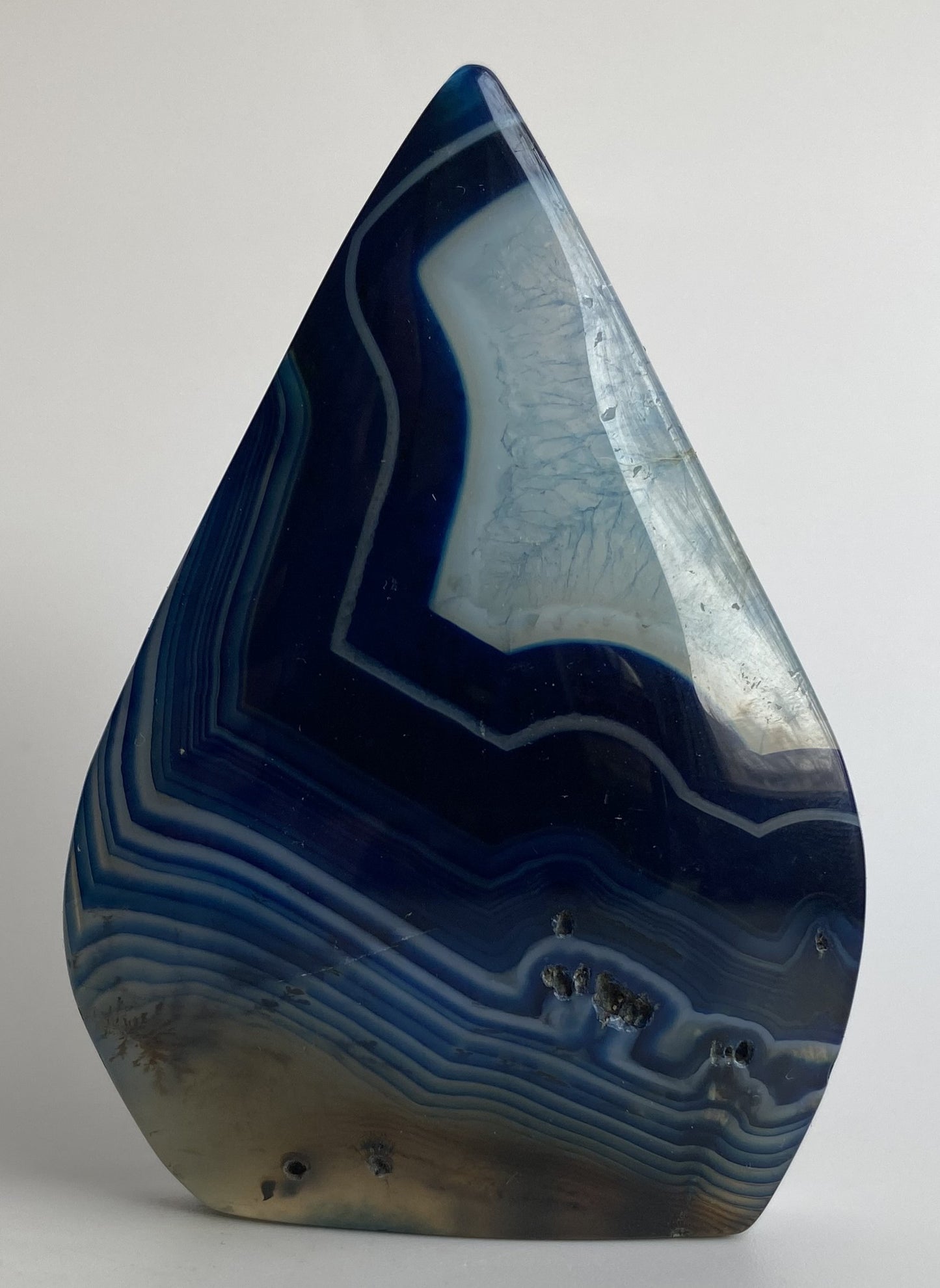 Sculptura din cristal de agat albastru pe fundal alb sub lumina naturala