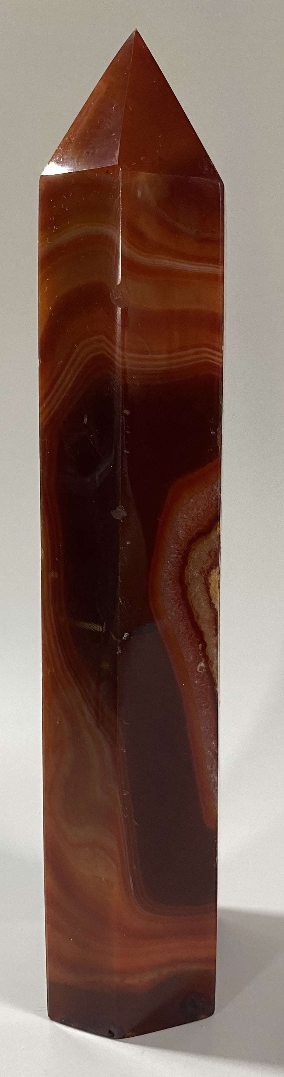Obelisk from red agate semi-precious stone with natural banding patterns
