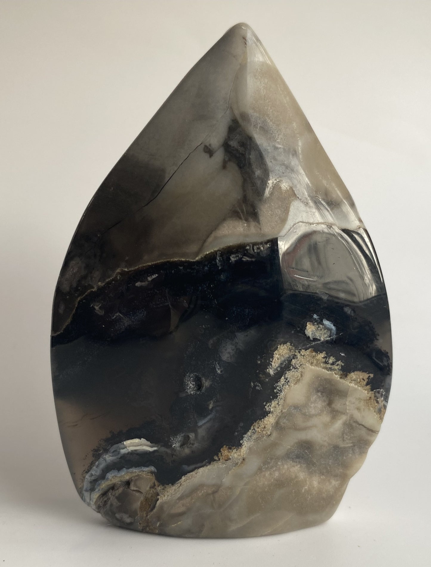 Sculptura din cristal de agat vulcanic pe fundal alb sub lumina naturala