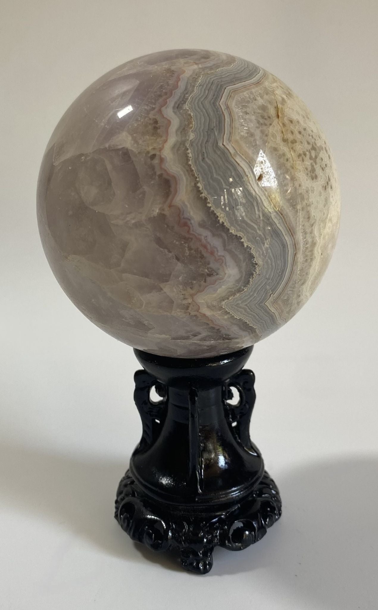 Sfera decorativa de 7.5cm din cristal de ametist cu agat pe suport decorativ cu fundal alb