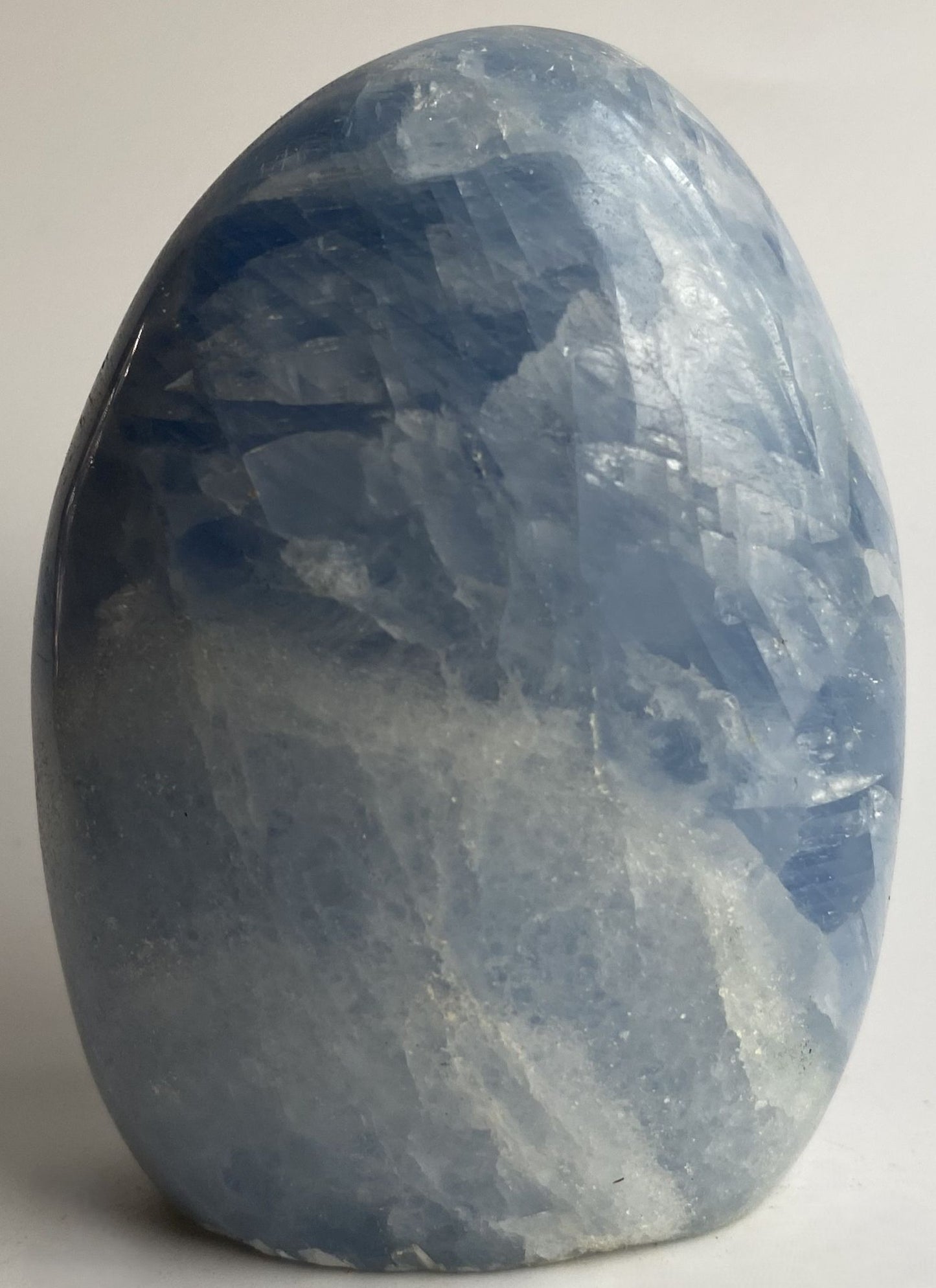 Sculptura din cristal de calcit albastru pe fundal alb