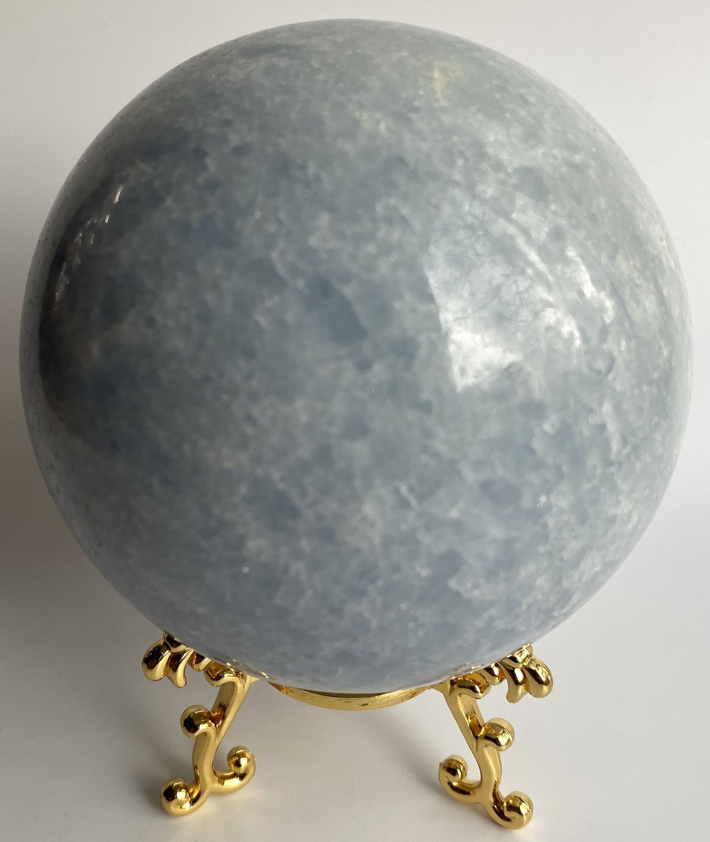 Sfera din cristal de calcit albastru pe suport metalic cu fundal alb