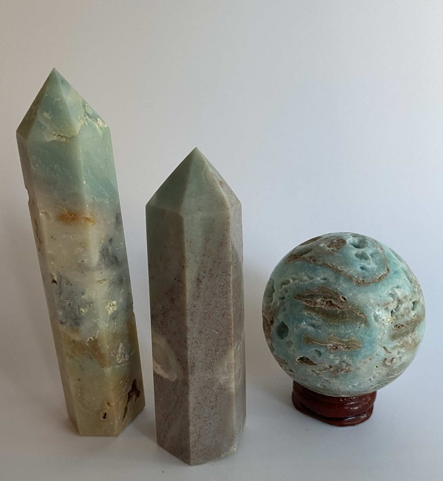 Set of two blue Calcit Caraibe obelisks and one Hemimorfit sphere on wooden stand