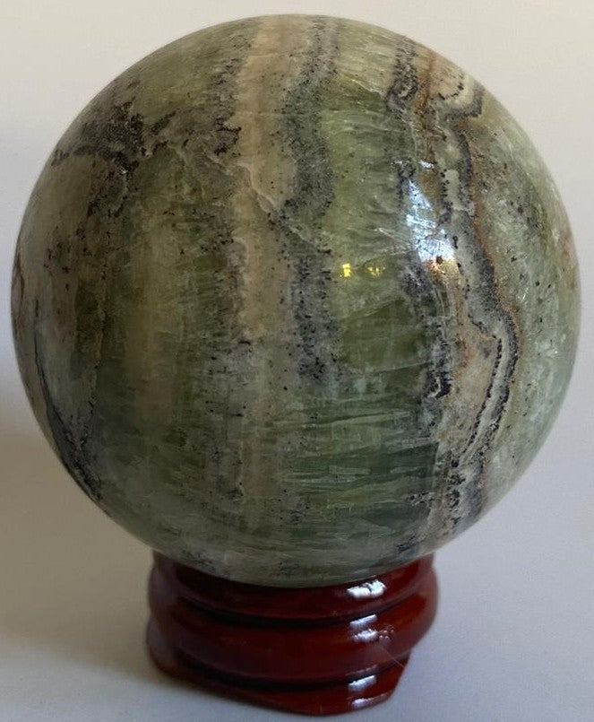 Sfera decorativa de 5.3cm din cristal de calcit caraibe verde pe suport din lemn cu fundal alb