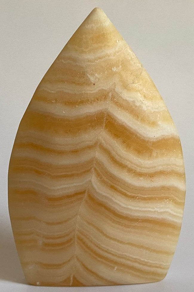 Sculptura de 9.3cm din mineral de calcit galben pe fundal alb