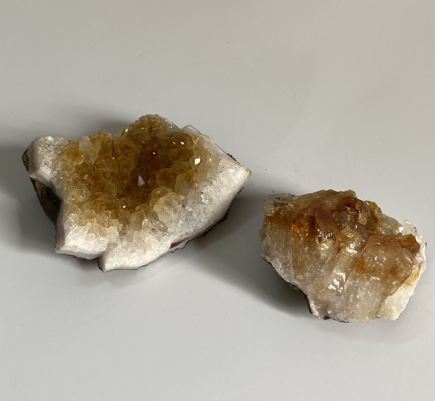 Doua fragmente de geoda de citrin pe fundal alb sub lumina naturala