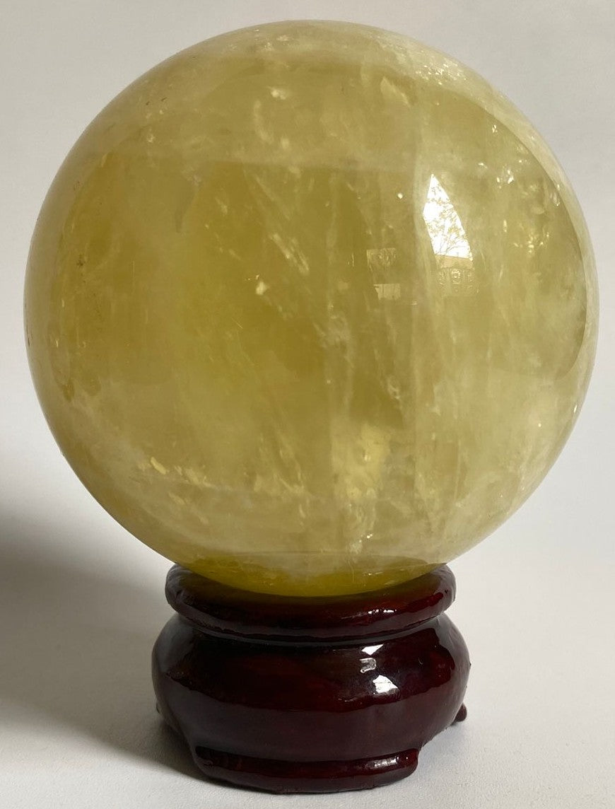 Sfera unicat de 7.6cm din piatra semipretioasa de citrin pe suport din lemn cu fundal alb