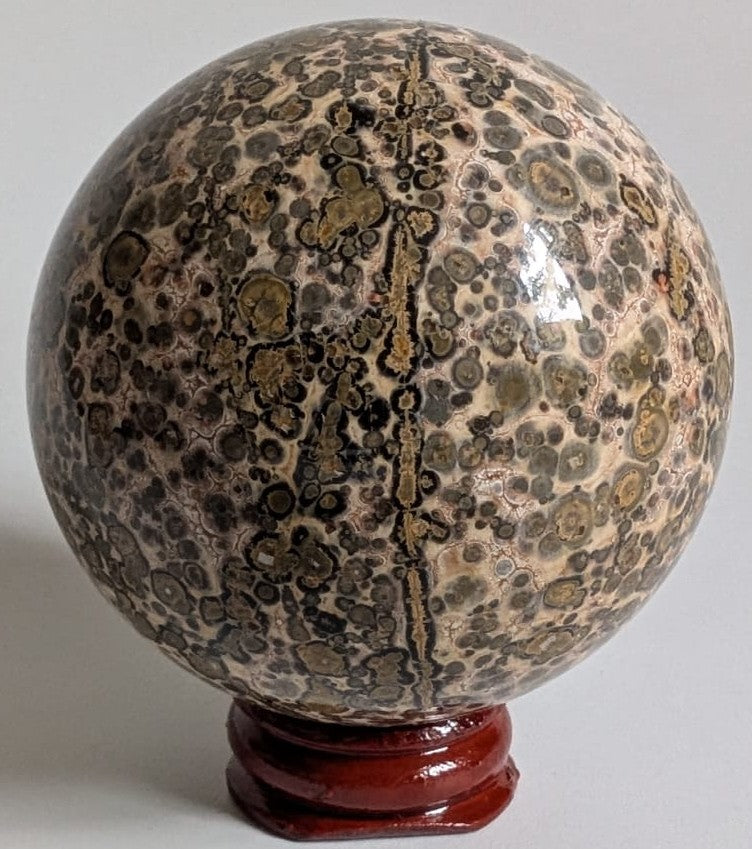 Sfera decorativa de 6.6cm din cristal de jasp leopard pe suport din lemn cu fundal alb