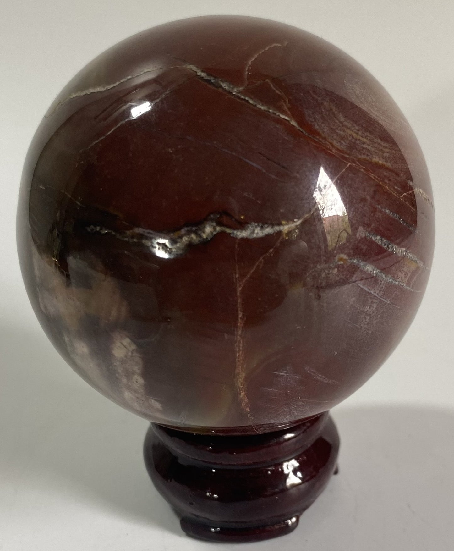 Sfera decorativa de 7cm din cristal de lemn fosilizat pe suport din lemn cu fundal alb