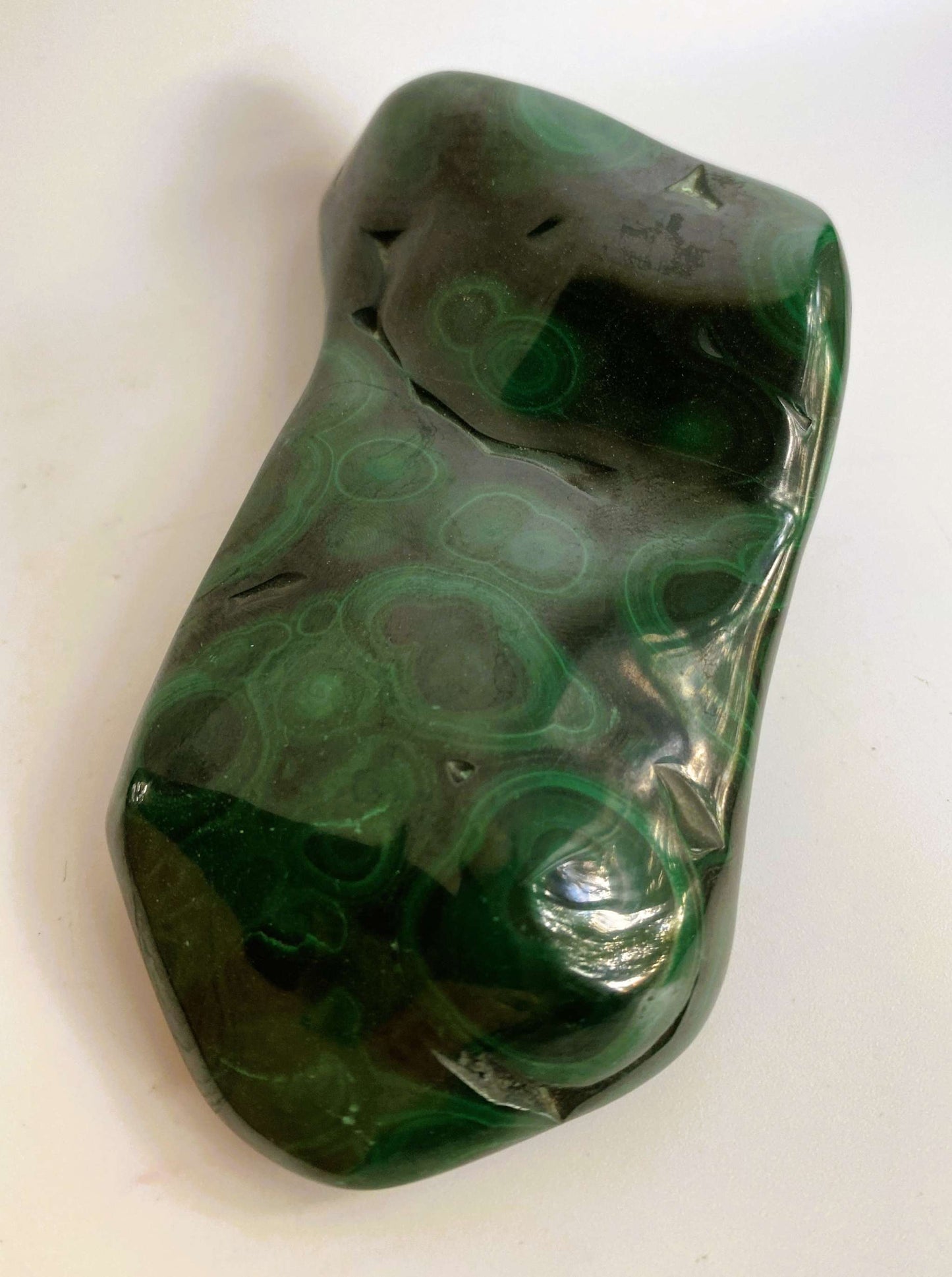 Malachit semiprecious stone specimen with green banded patterns on white background