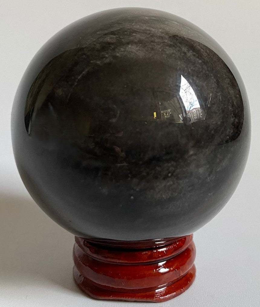 Sfera unicat de 5.4cm din piatra semipretioasa de obsidian argintiu pe suport din lemn cu fundal negru