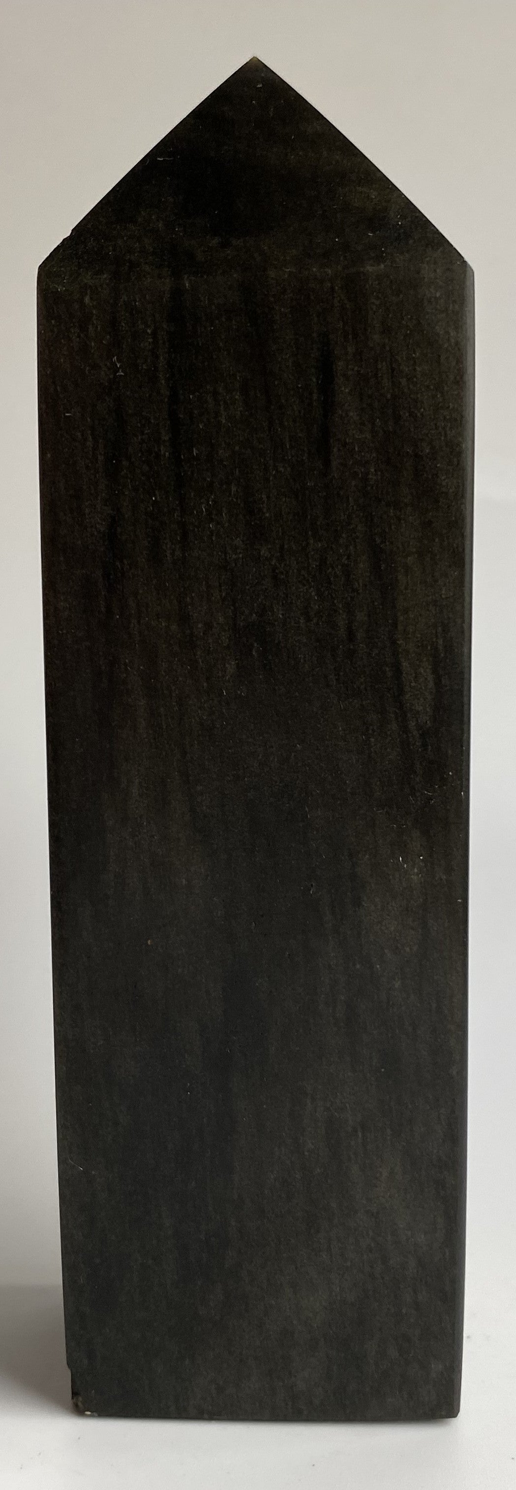 Obelisc din mineral de obsidian auriu pe fond alb si in lumina naturala