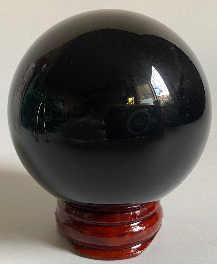 Sfera de 5.3cm din cristal de obsidian curcubeu pe suport din lemn cu fundal alb