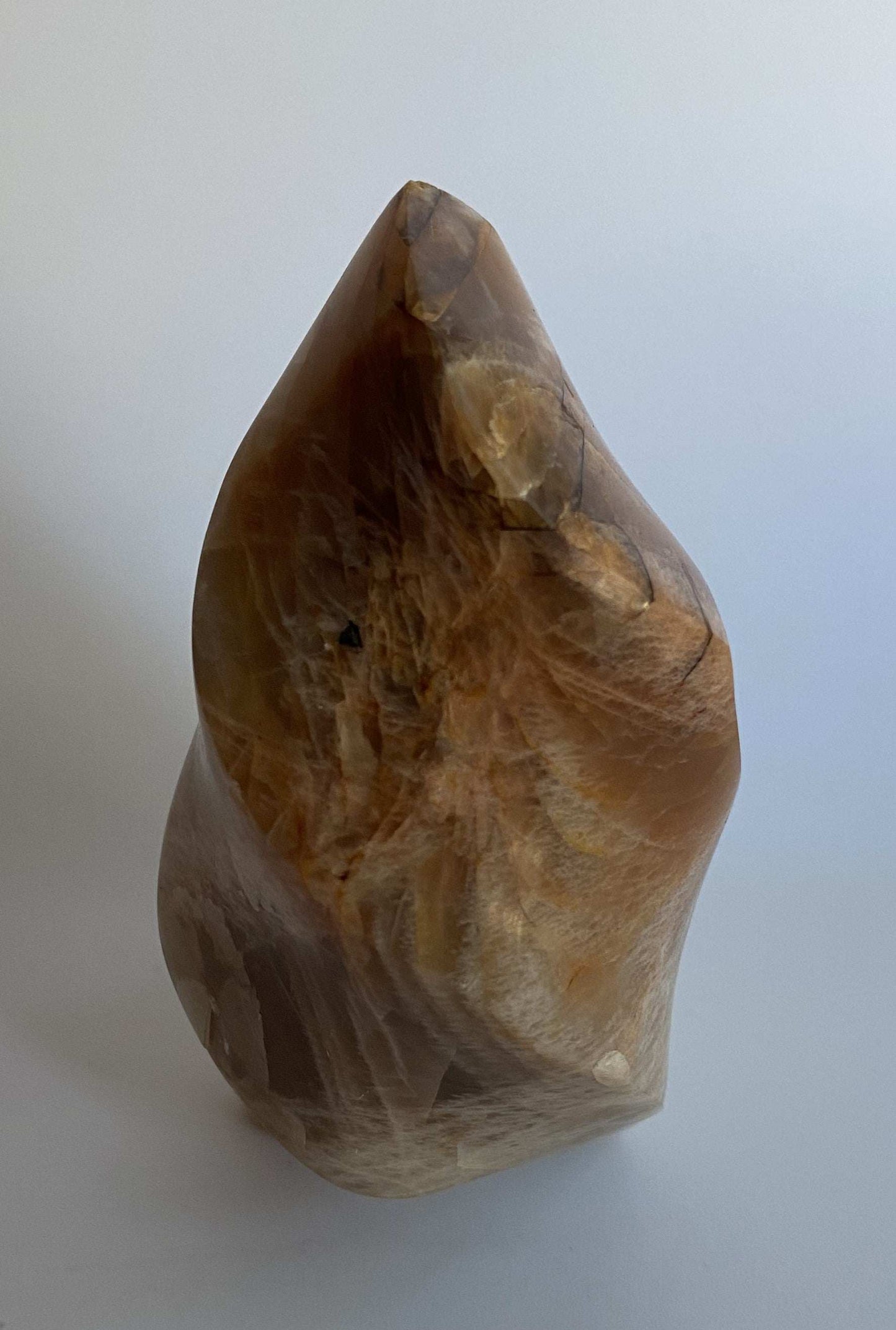 Sculptura din piatra lunii portocalie semipretioasa naturala pe fundal alb