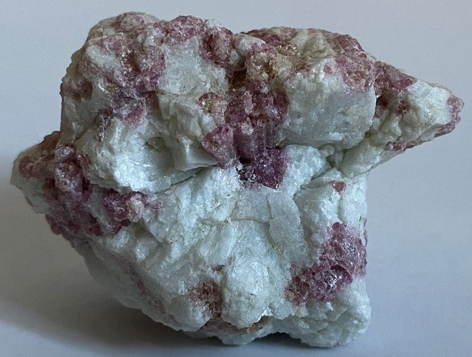 Piatra bruta decorativa de 6.4cm din cristal de turmalina rosie pe fundal alb