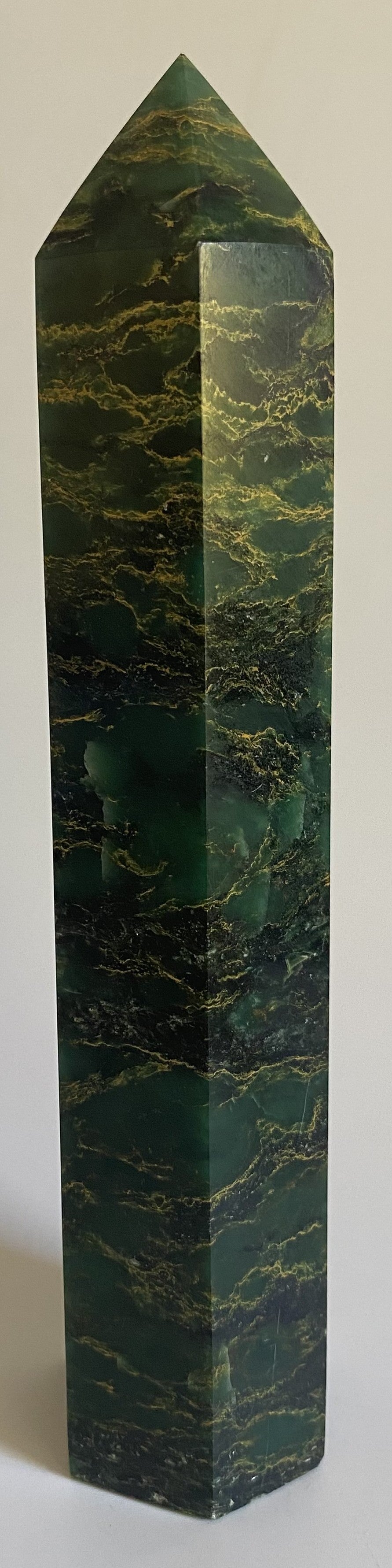 Obelisc din verdit pe fond alb sub lumina naturala