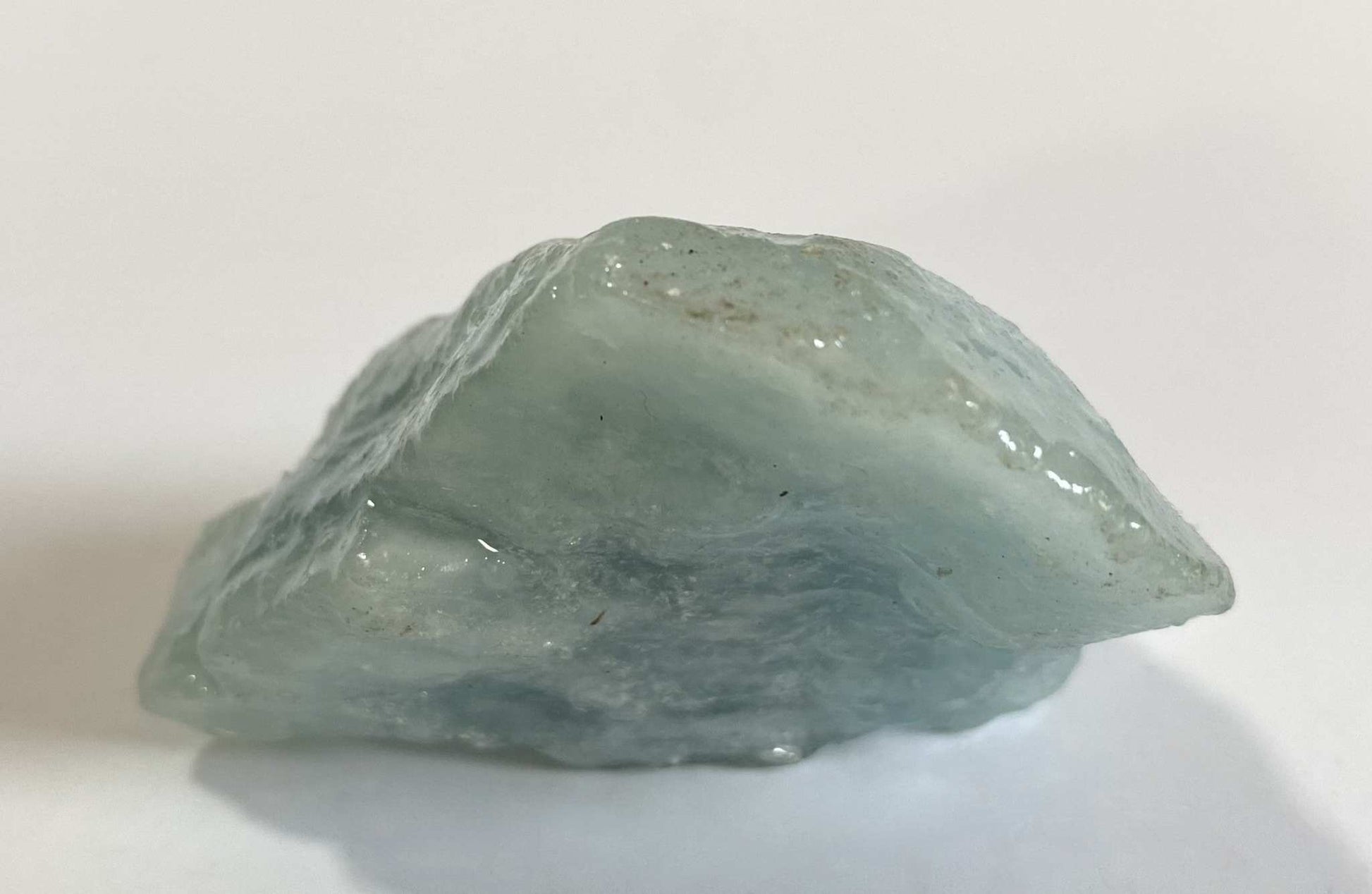 Piatra bruta din piatra semipretioasa de Acvamarin pe fundal alb, vedere laterala.