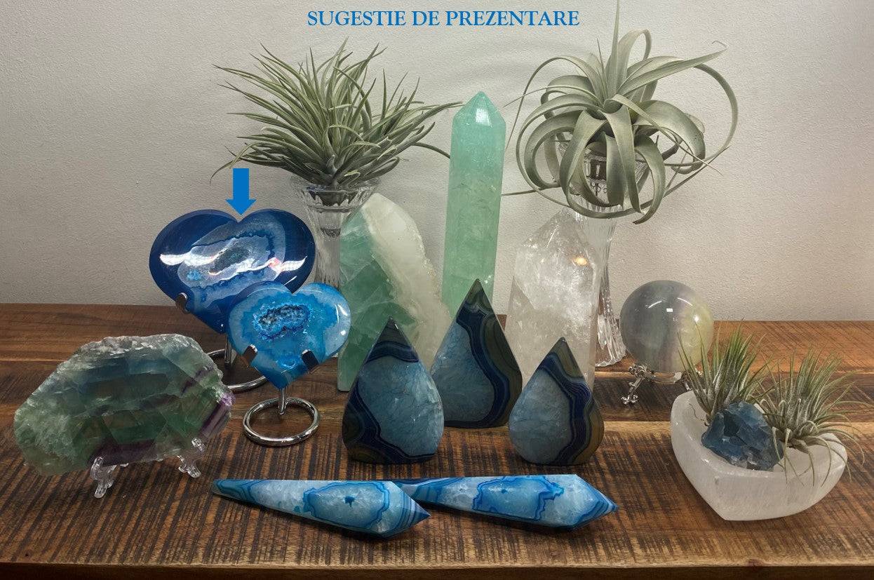Inima din Agat Albastru pe suport metalic albastru, prezentata printre alte cristale decorative pe masa din lemn