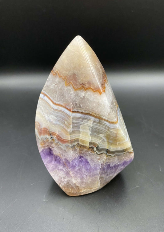 Simbiot Agat-Ametist sculpted semi-precious stone with purple and beige layers on black background