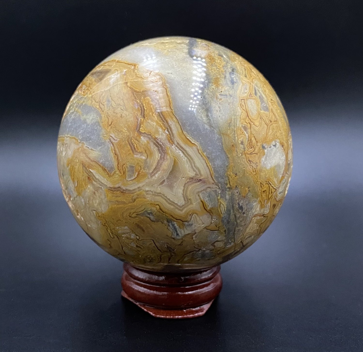 Sfera din cristal de agat crazy lace pe suport din lemn cu fundal negru