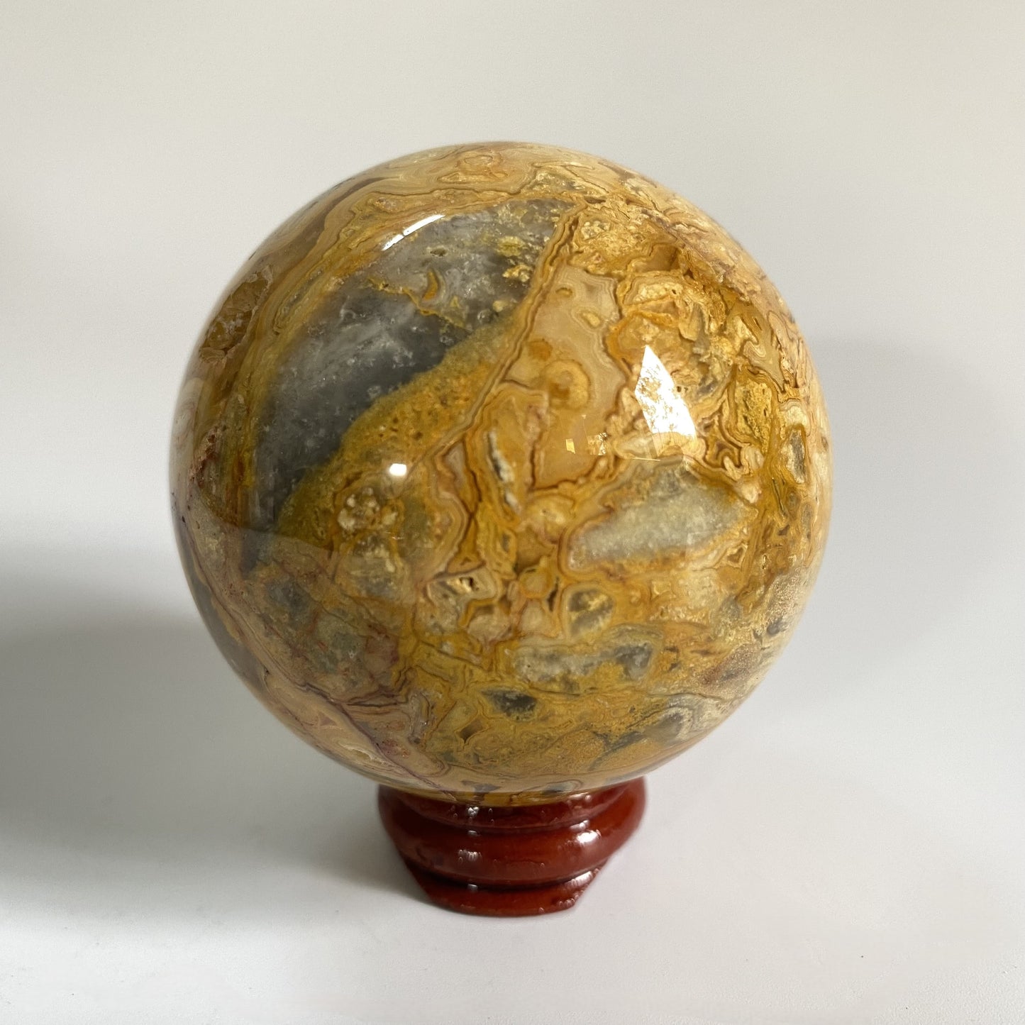 Sfera decorativa din cristal de agat crazy lace pe suport din lemn cu fundal alb