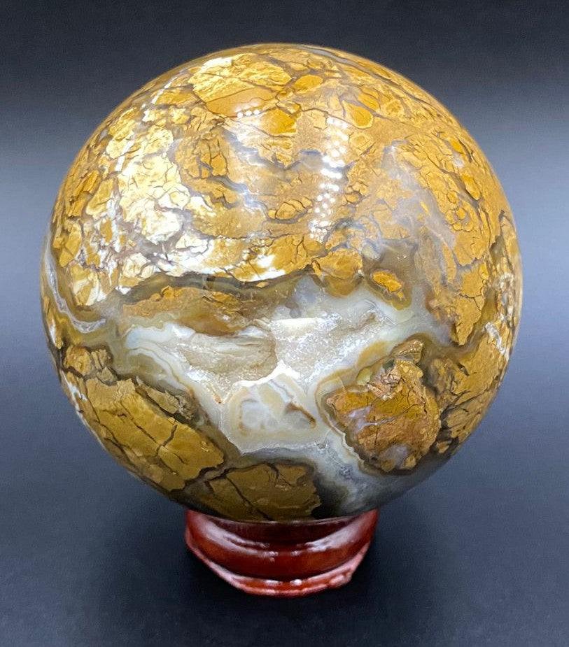 Sfera din piatra semipretioasa de agat indonezia pe suport de lemn cu fundal negru