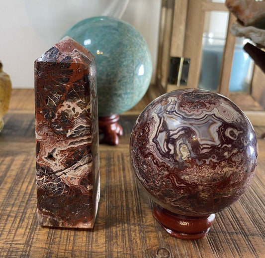 Agat Mexican set with brown patterned obelisk and sphere on wooden stand on wooden surface