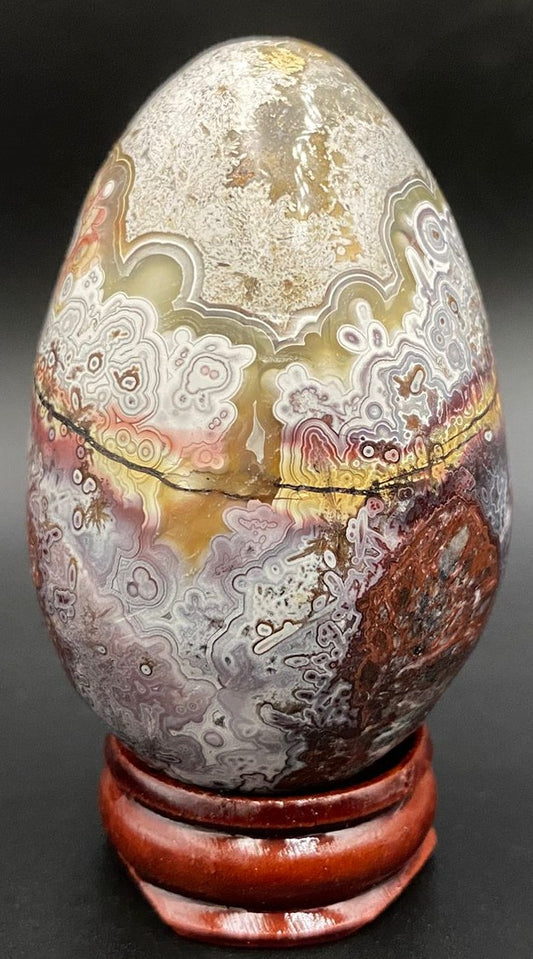 Ou din piatra semipretioasa de agat mexican pe suport din lemn cu fundal negru