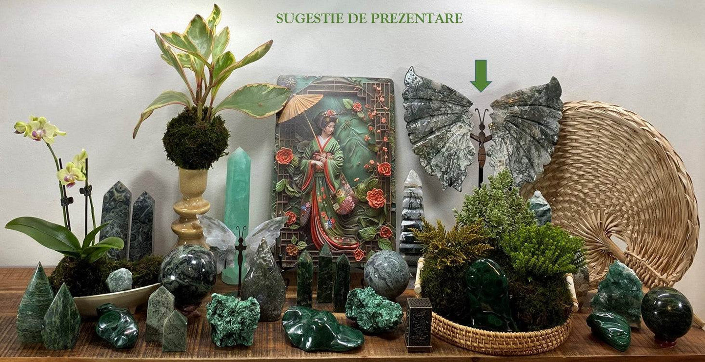 Agat Muschi butterfly stone sculpture on metal stand among green crystals and plants