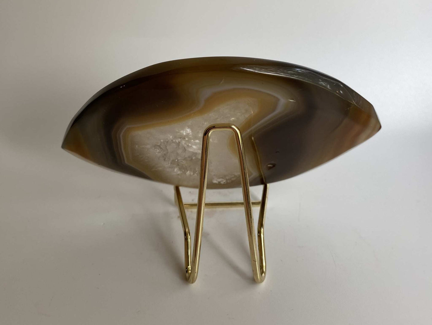 Agat natural semi-precious stone slice with metal stand on white background