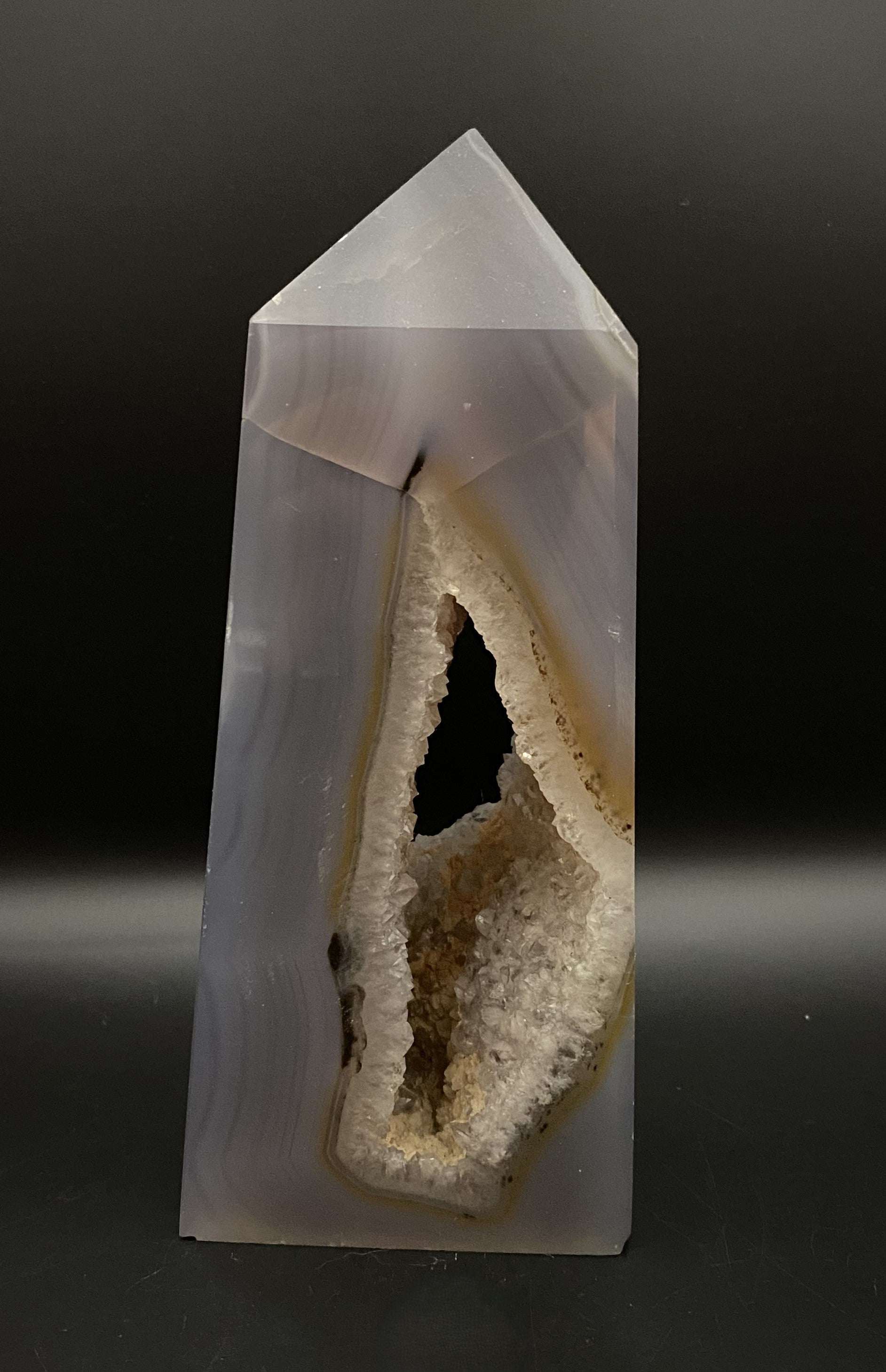 Agat Natural obelisk with geode on black background