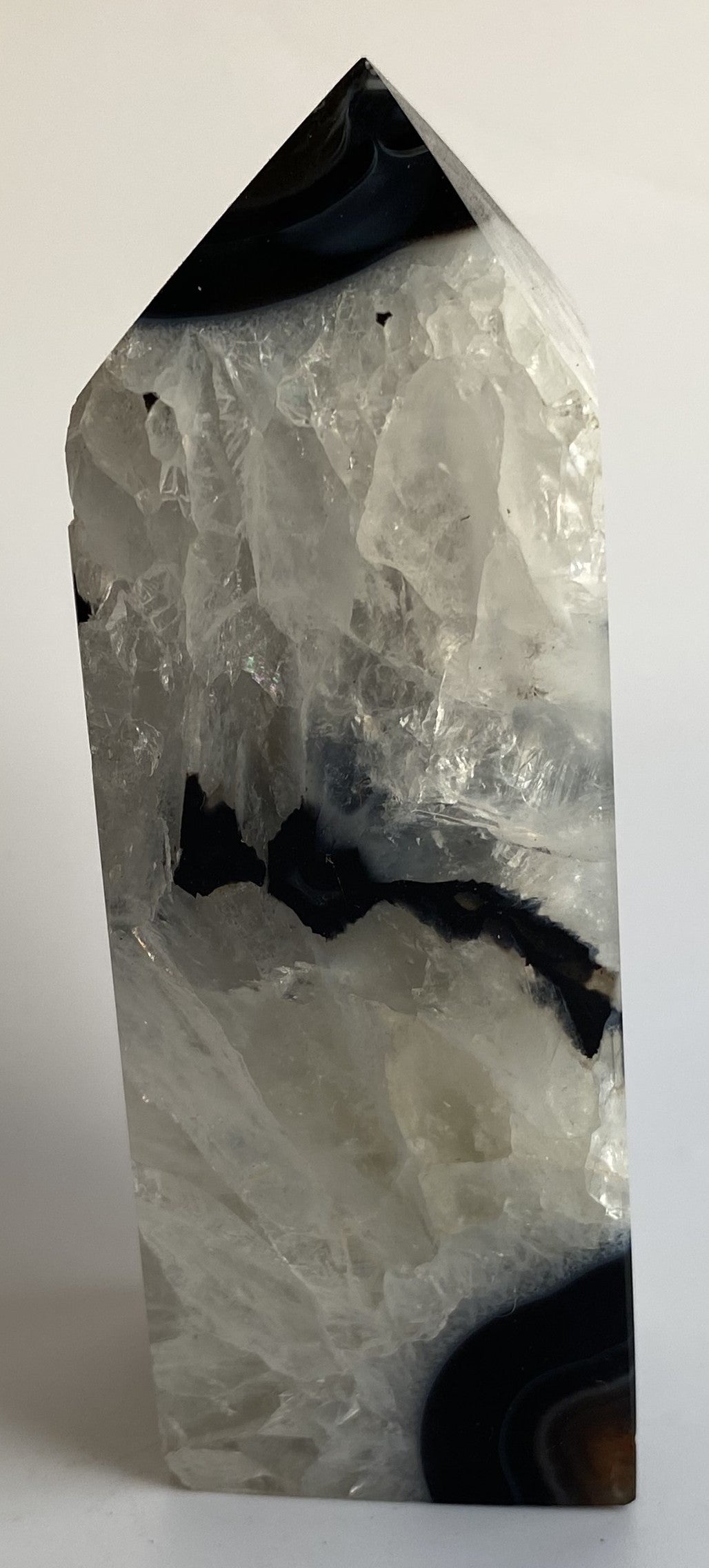 Obelisc din cristal de agat negru pe fundal alb sub lumina naturala