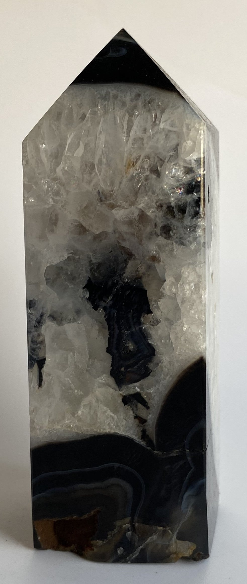 Obelisc din cristal de agat negru pe fundal alb sub lumina naturala