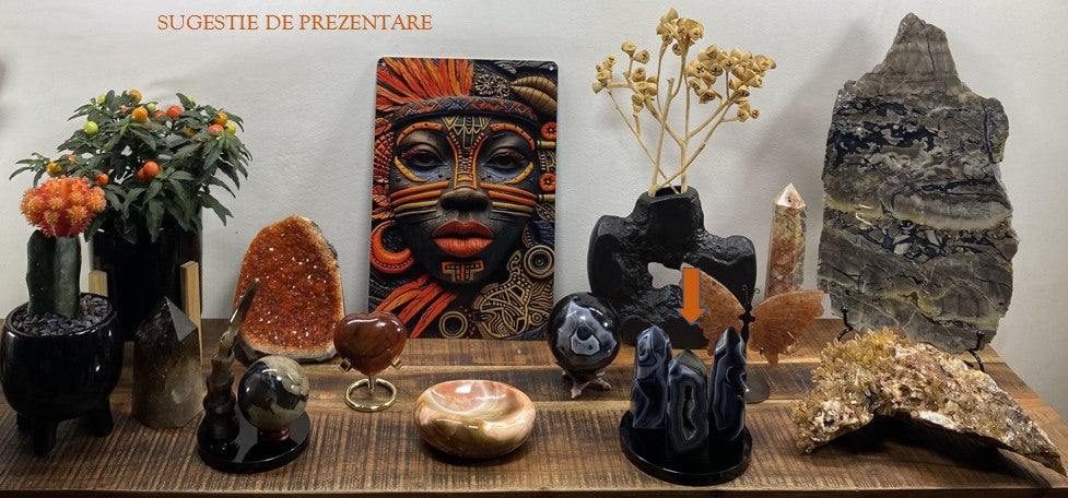 Set of three black Agate obelisks displayed on a wooden surface among other decorative stones and plants
