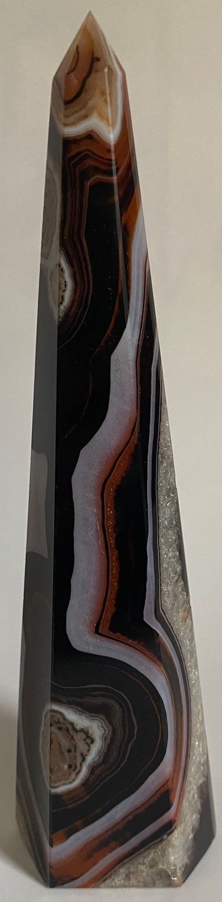 Obelisc piramidal din cristal de agat negru-rosu pe fundal alb