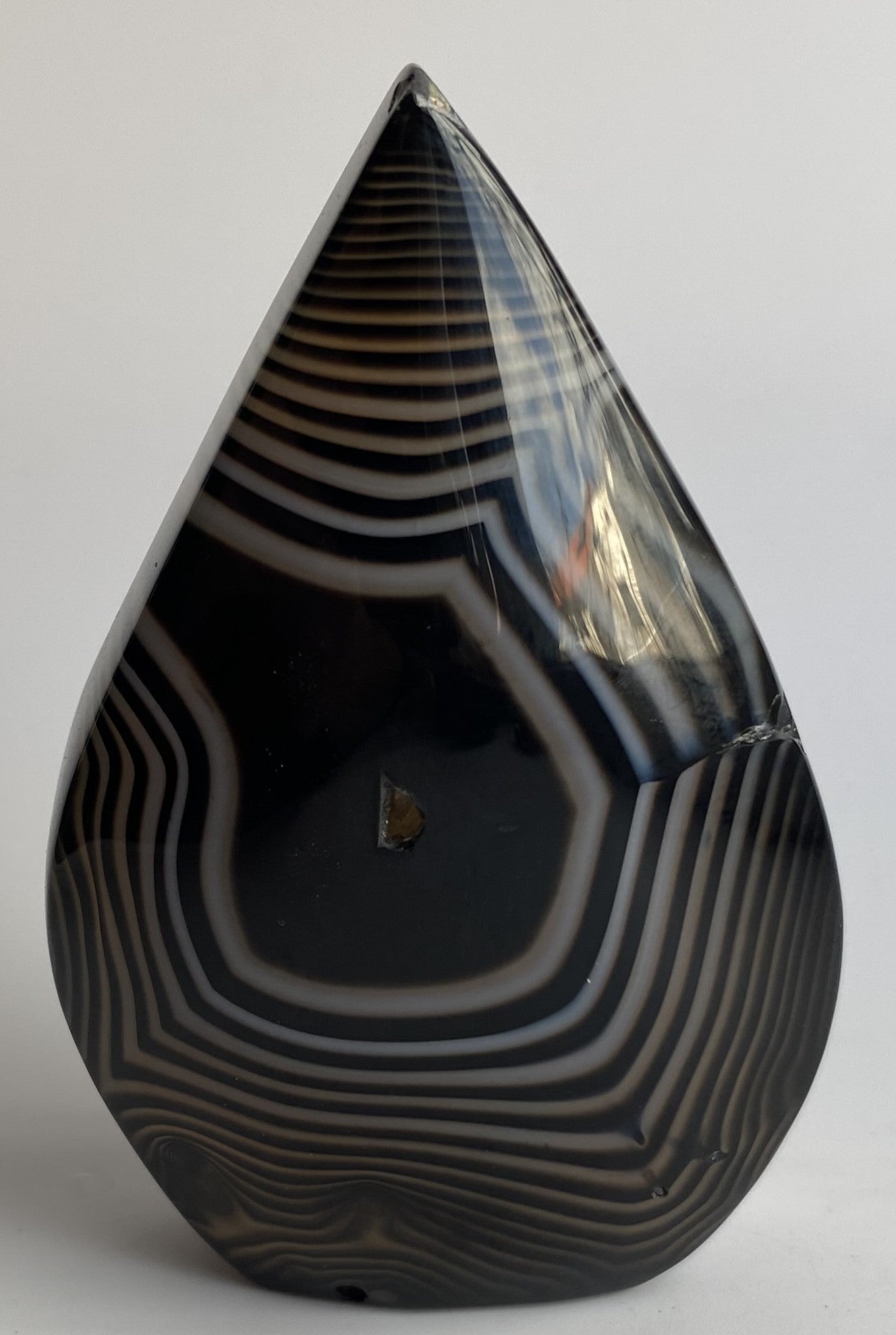Sculptura din cristal de agat negru pe fundal alb sub lumina naturala