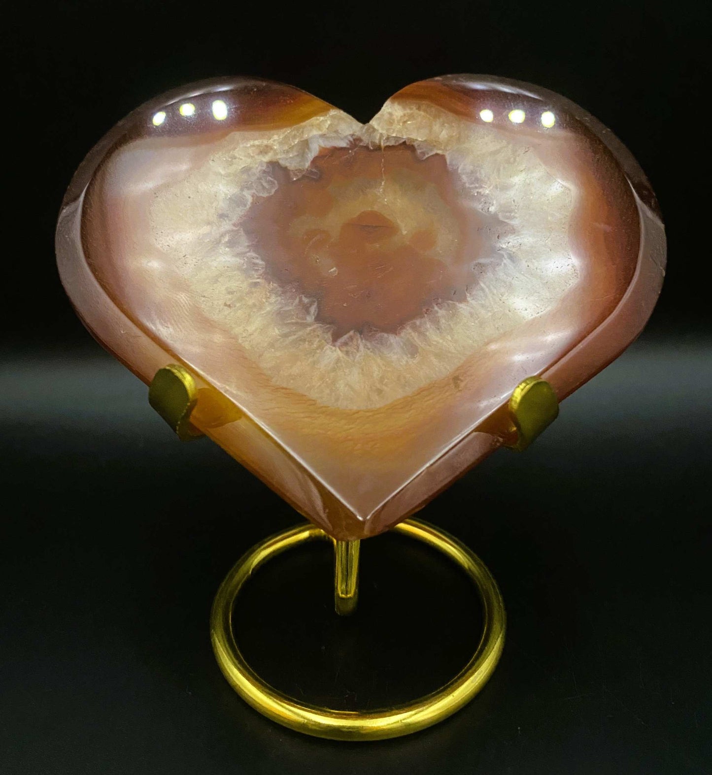 Heart-shaped red agate geode stone on metal stand