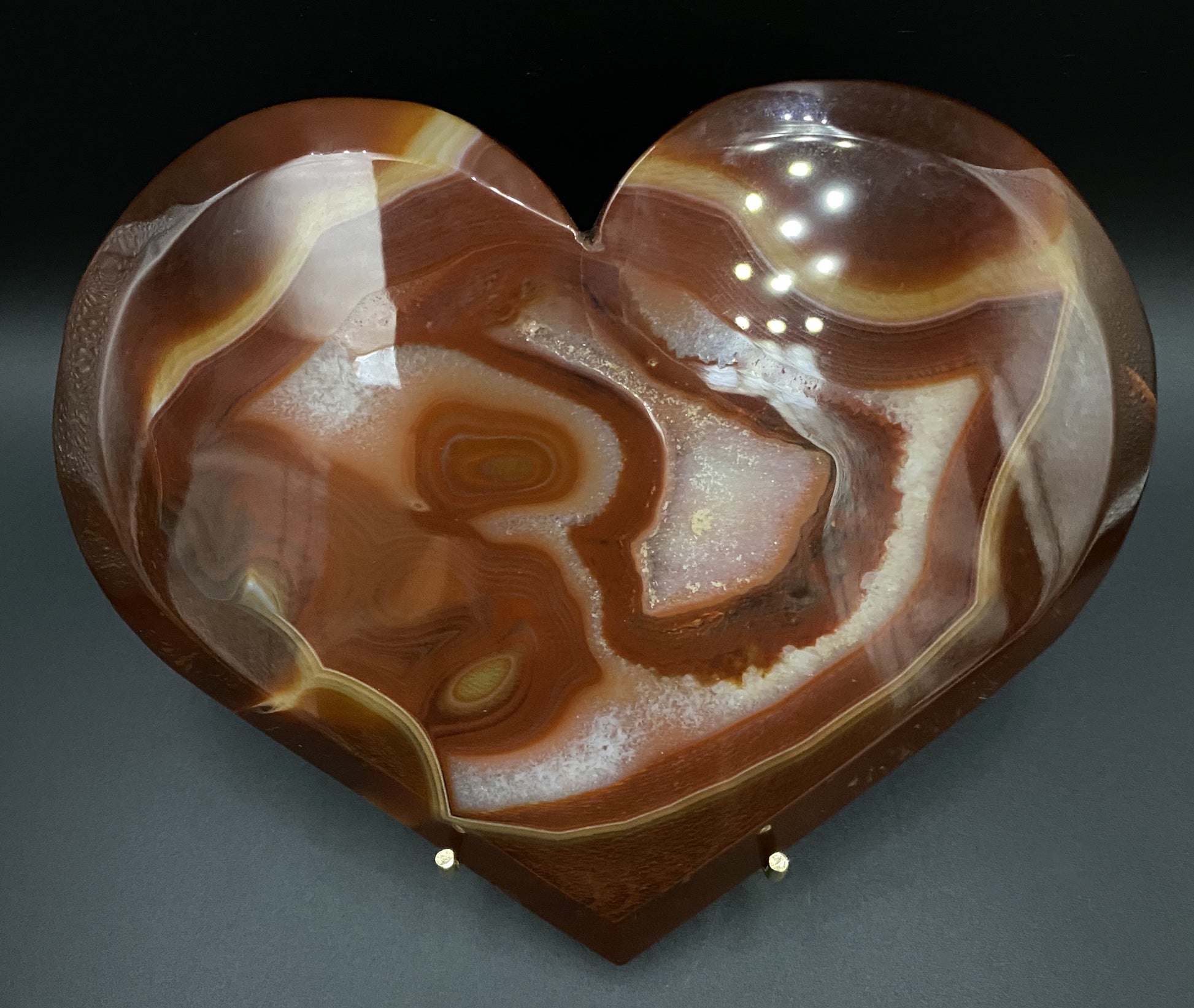 Inima din geoda de agat rosu pe fundal negru sub lumina artificiala