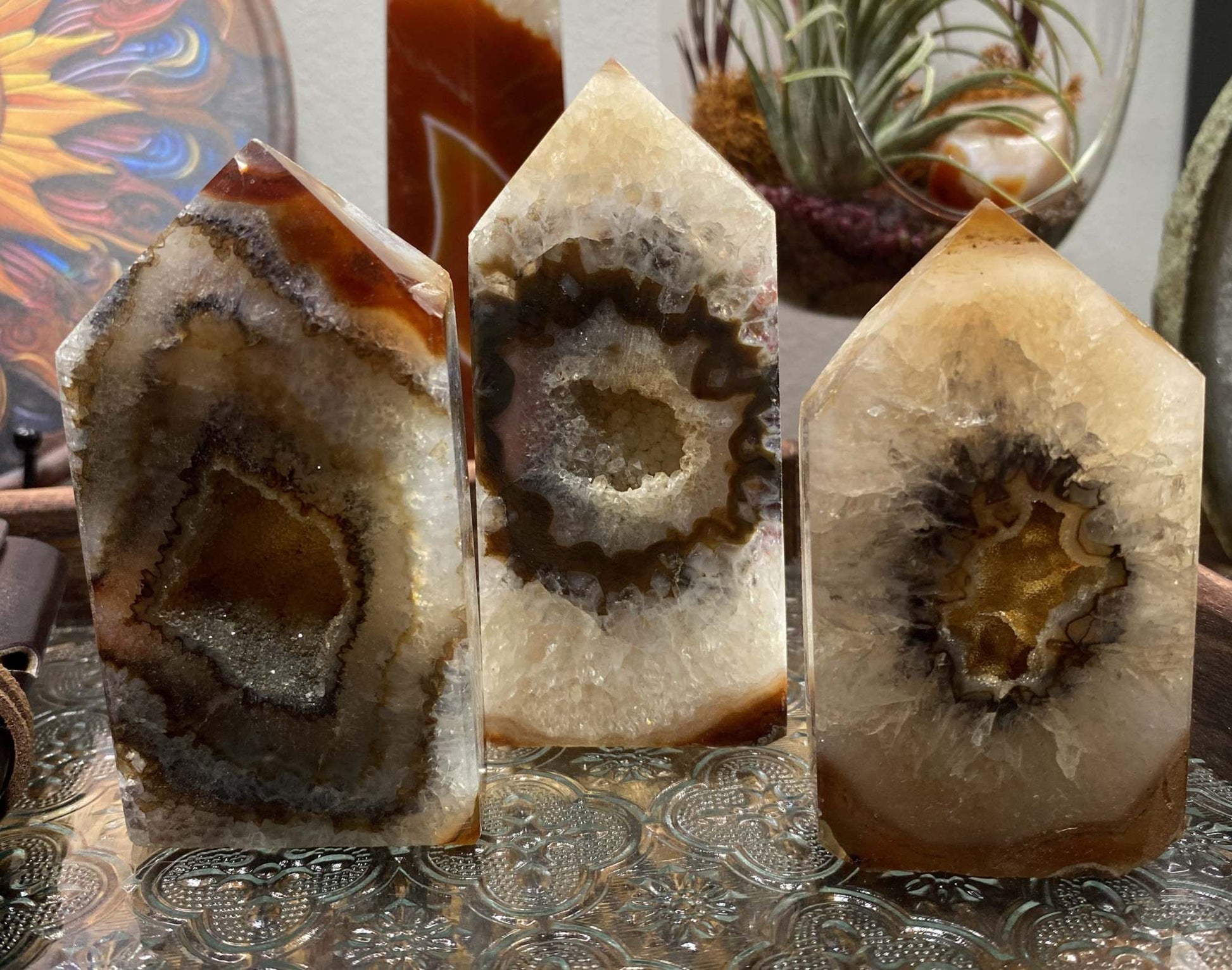 Set of three Agat Rosu red agate obelisks from geode stones on decorative surface