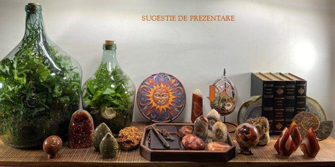 Set of three red agate obelisks from geode on wooden surface with plants and books background