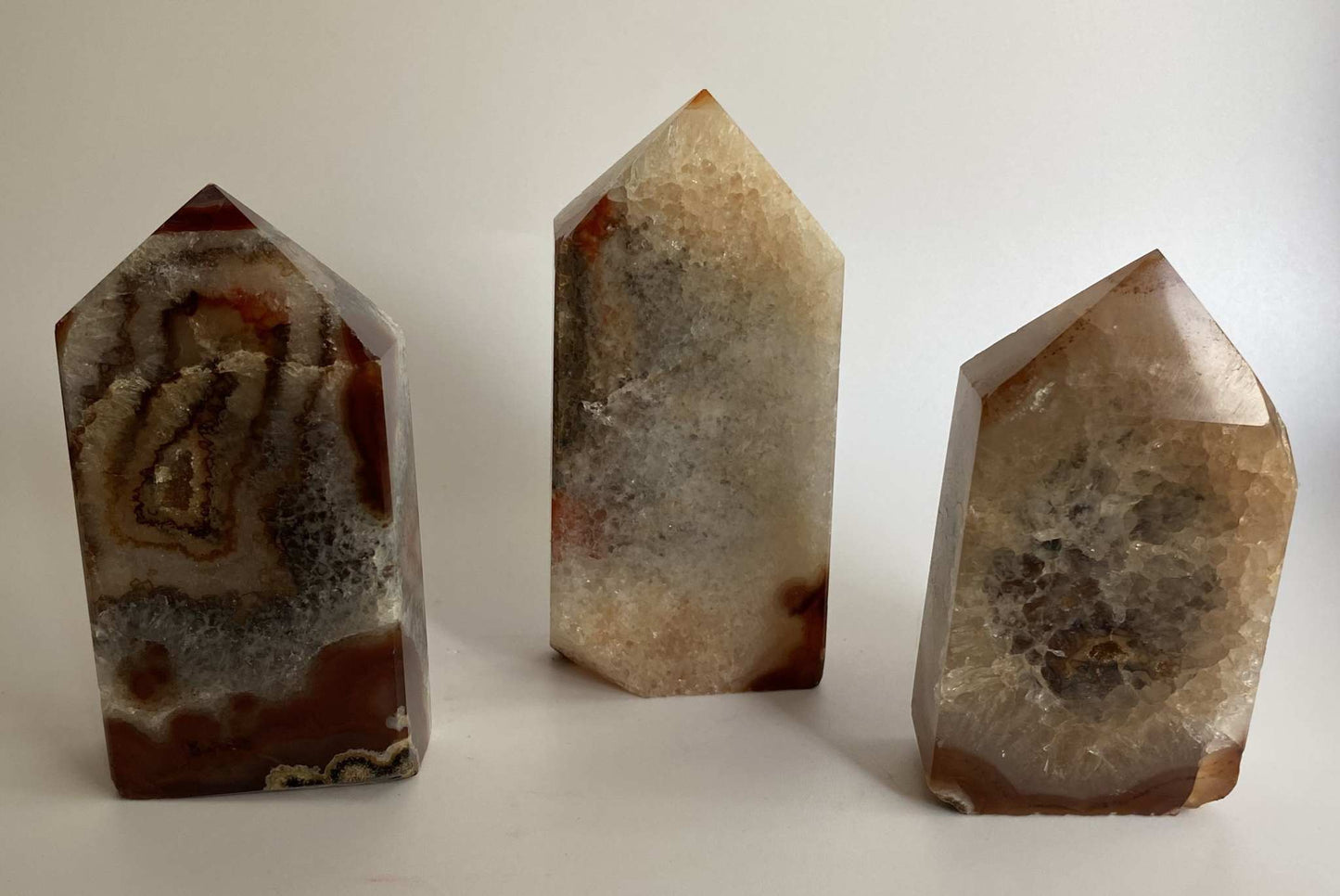 Set of three red agate obelisk gemstones with natural patterns