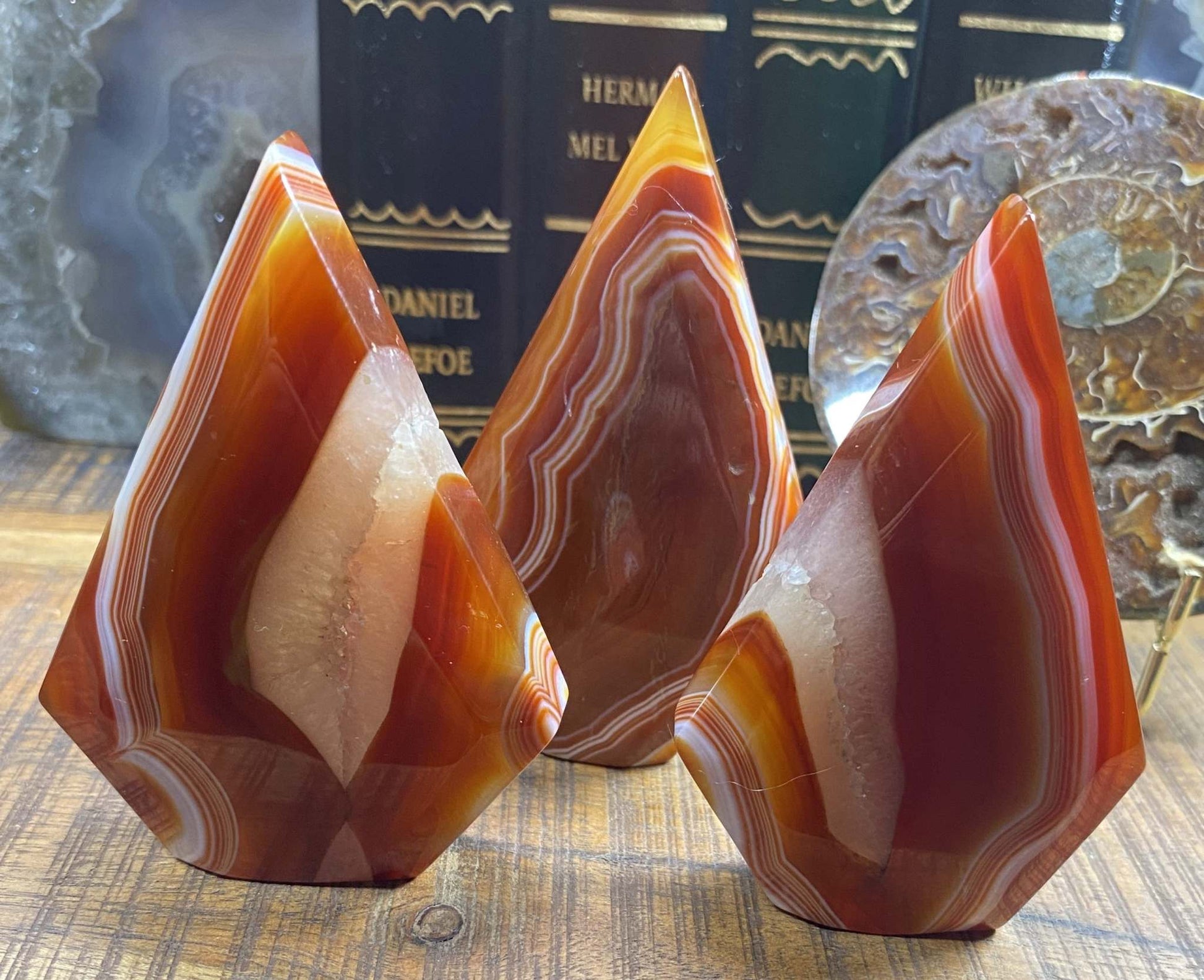 Set of three red agate gemstone sculptures with natural banding patterns