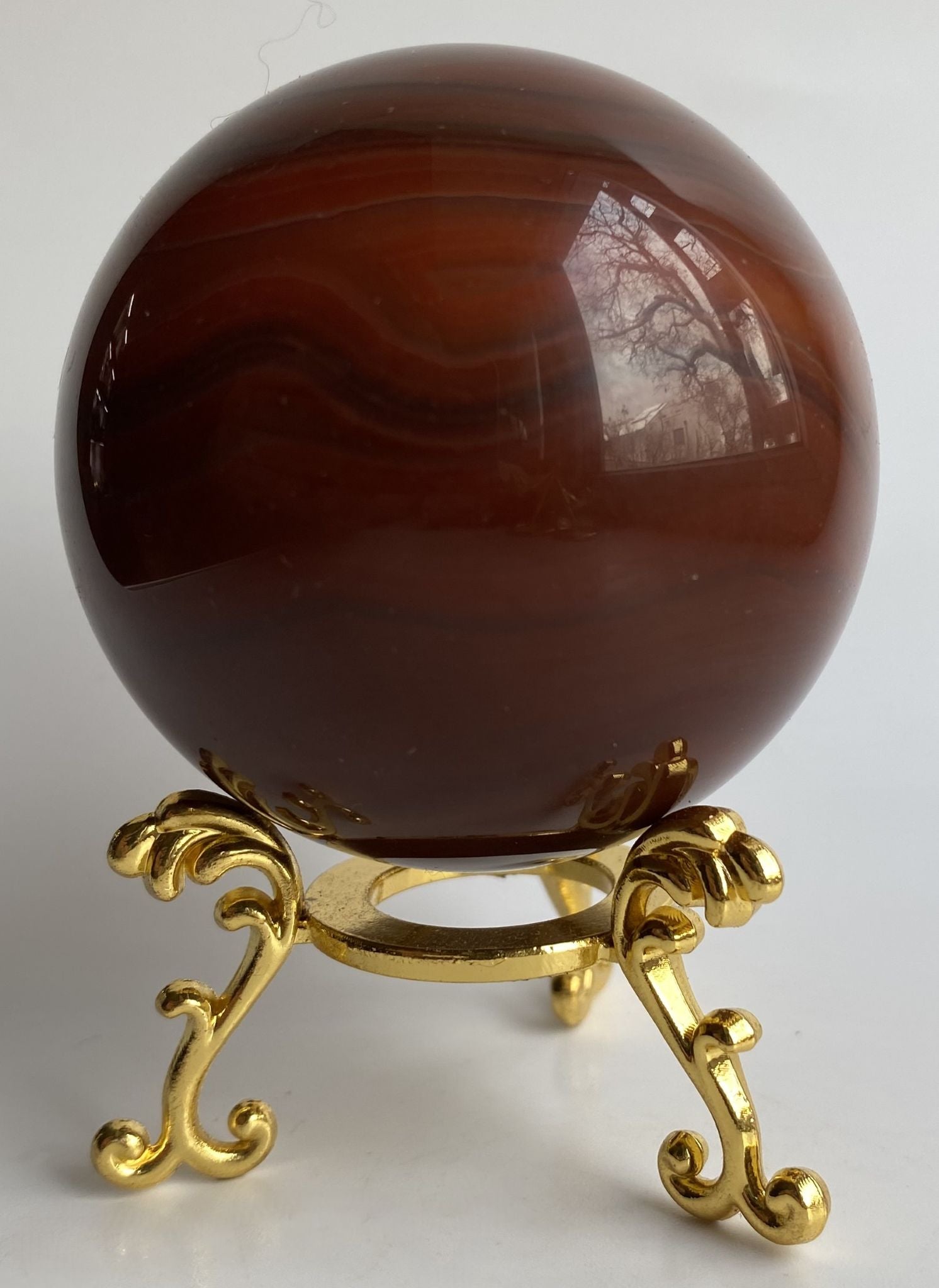 Sfera de 6cm din cristal de agat rosu pe suport metalic cu fundal alb