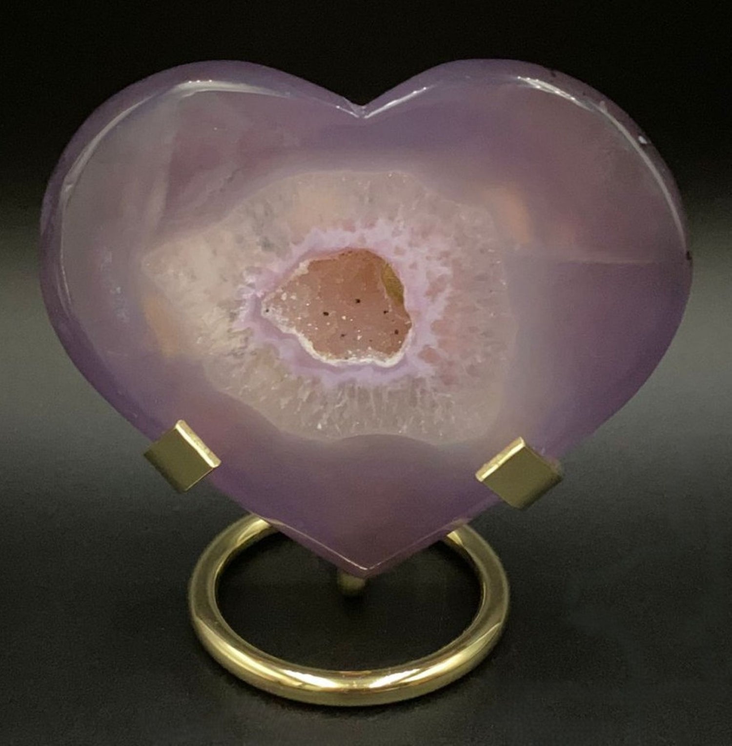 Inima din cristal de agat roz pe suport metalic si fundal negru