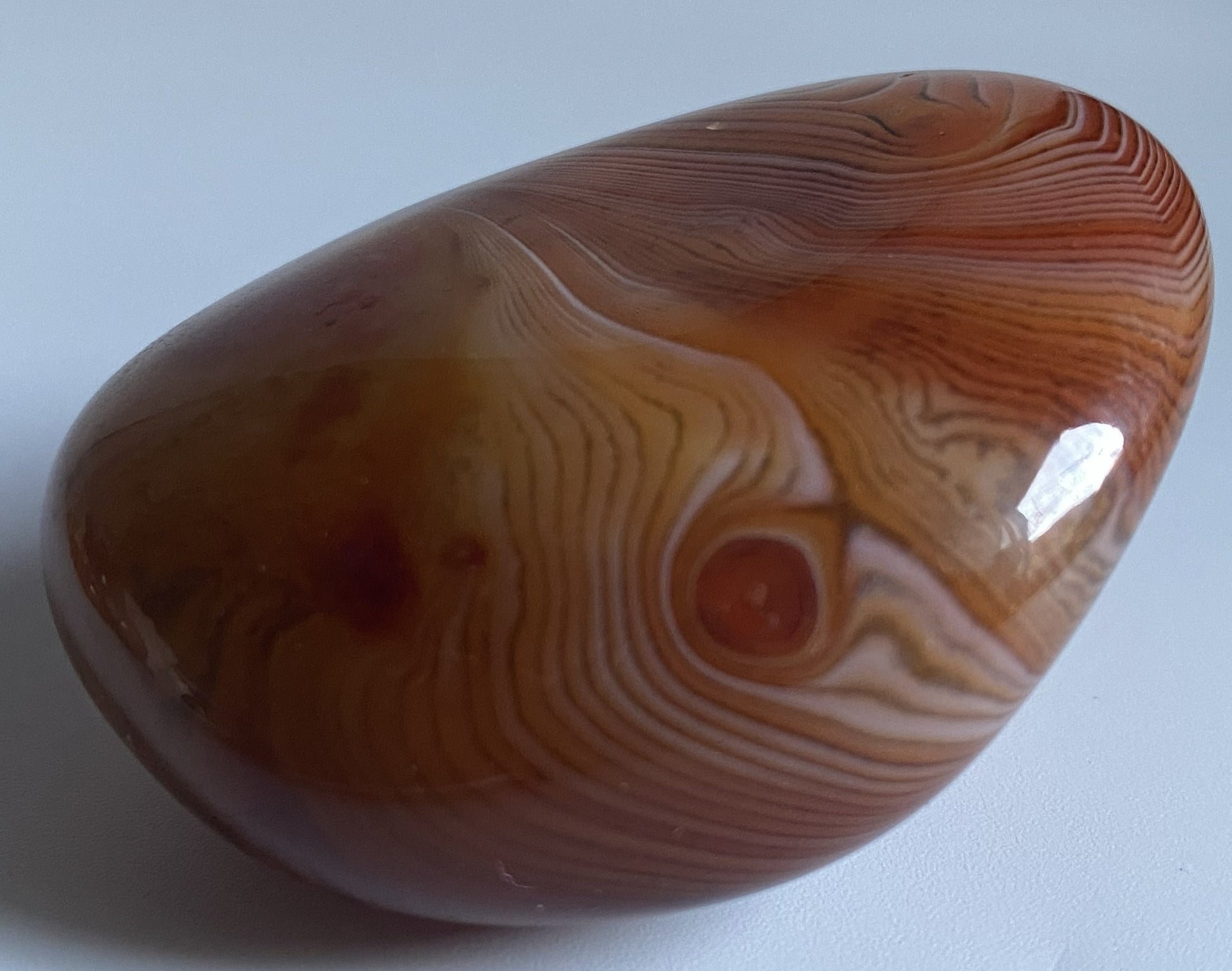 Piatra polisata decorativa de 5.5cm din piatra semipretioasa de agat sardonyx pe fundal alb