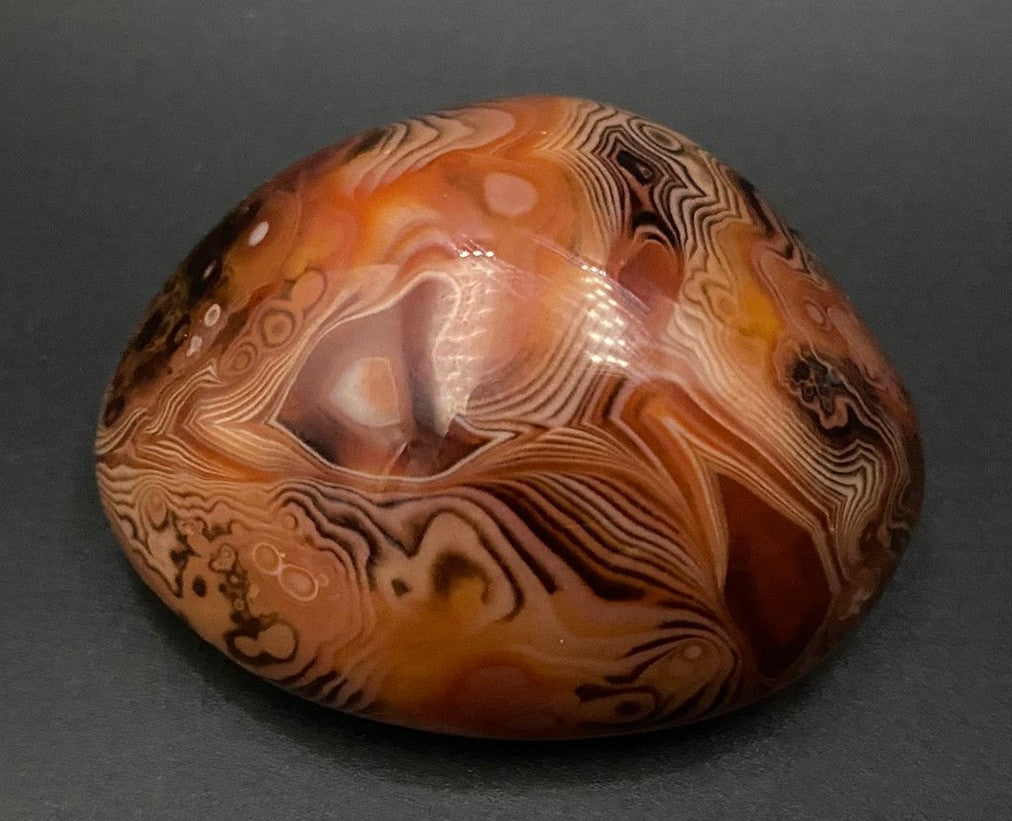 Piatra polisata din piatra semipretioasa de agat sardonyx pe fundal negru