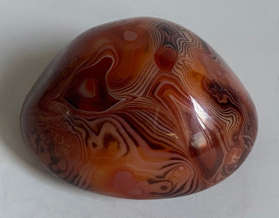 Piatra polisata din cristal de agat sardonyx pe fundal alb