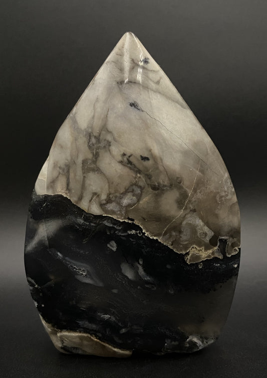 Sculptura din cristal de agat vulcanic pe fundal negru sub lumina artificiala