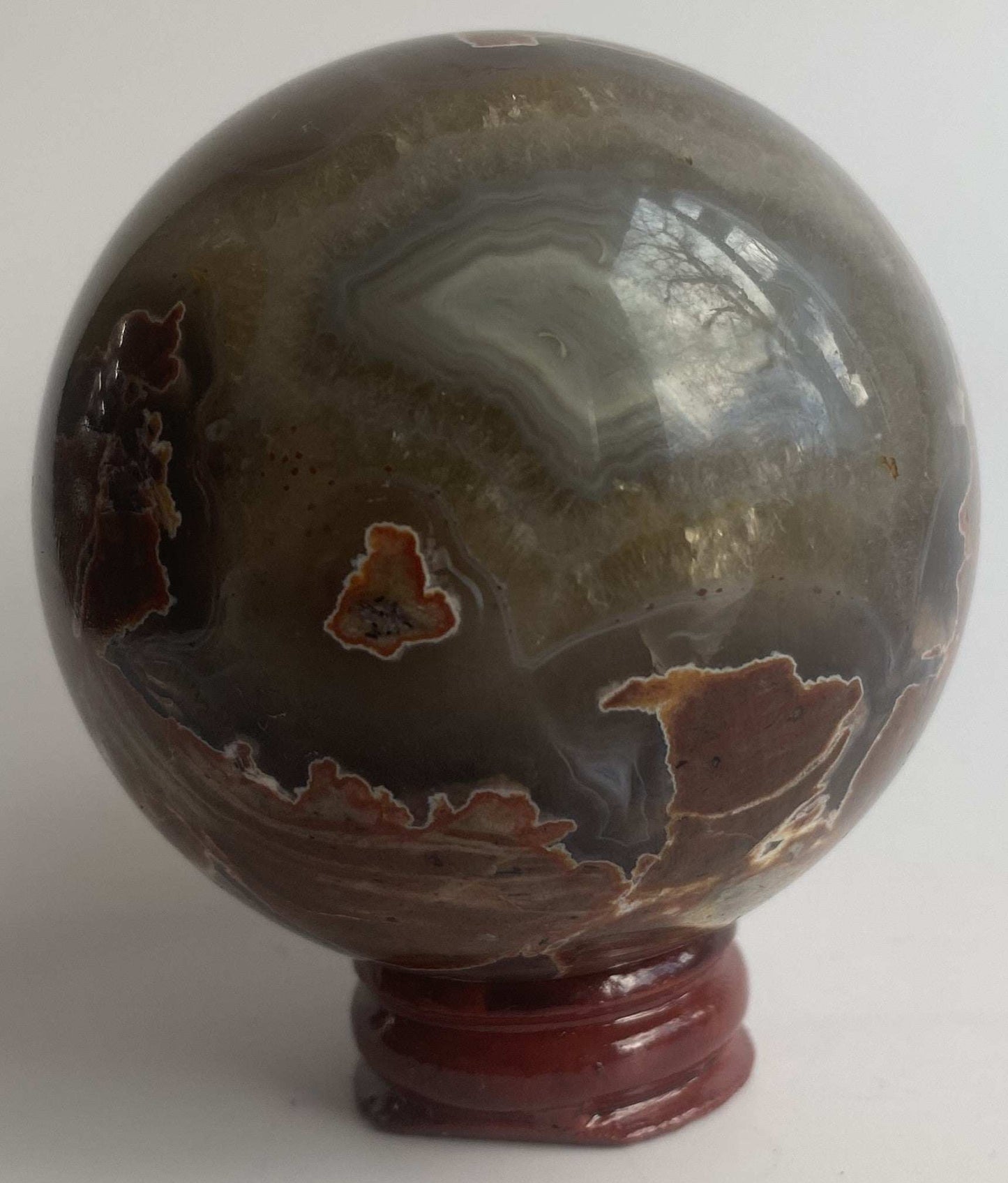 Sfera unicat de 6.5cm din piatra semipretioasa de agat vulcanic pe suport din lemn cu fundal alb